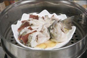 將鱸魚成花狀擺好，將火腿切片放入各縫隙中，放入鍋中隔水蒸12分鐘拿出，撒上蔥花即可。