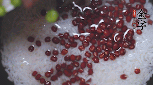 將炒好的食材和大米、紅豆一起放進(jìn)電飯鍋煮。