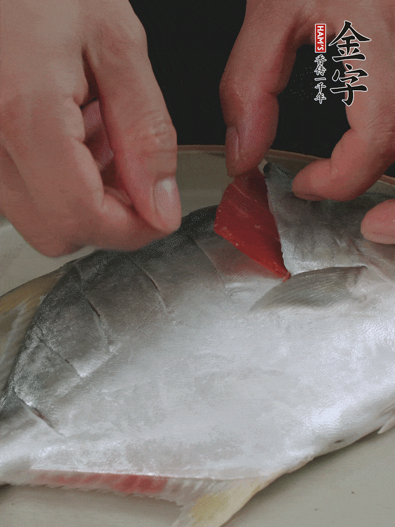 火腿片和姜片塞在刀口處，也塞一些入魚(yú)肚。
