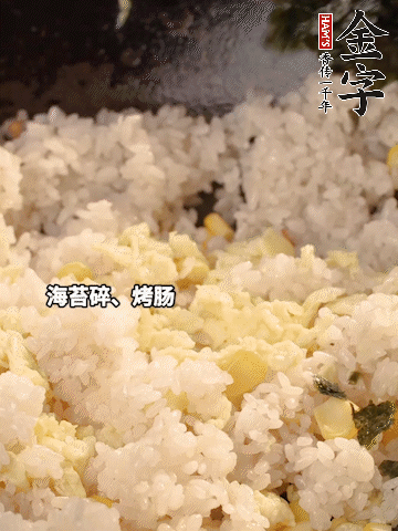 剩米飯下鍋炒散，依次下玉米粒、雞蛋、烤腸、海苔碎翻炒均勻。