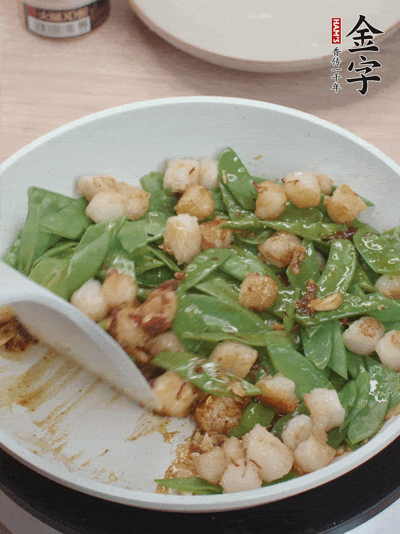 下甜豆莢、鮮貝輕輕翻炒均勻。