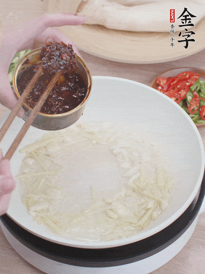 起鍋熱油，姜蒜、金字火腿干貝醬煸香。
