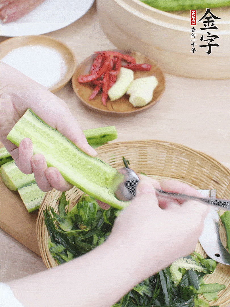 黃瓜削皮，對(duì)半切開(kāi)，勺子挖去內(nèi)瓤，斜刀切片。青蒜斜刀切段。
