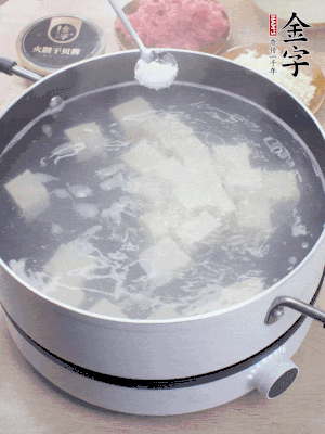 豆腐切成大小均勻正方體，鍋內(nèi)放水，加一點鹽焯水10秒。