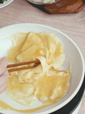 油6成熱時(shí)，下雞蛋液，邊緣凝固時(shí)翻拌成塊狀。
