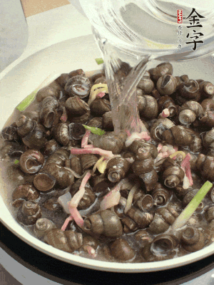 倒處理干凈的螺螄翻炒，加3勺料酒。加清水蓋過(guò)螺螄，中火蓋蓋煮5分鐘。