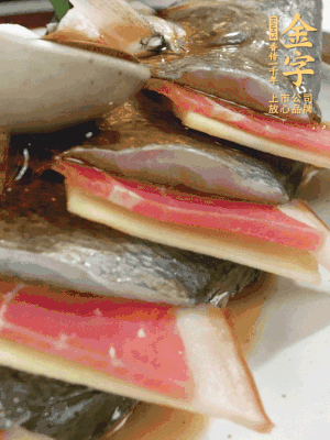 魚肚中塞蔥結(jié)、火腿片，魚身上碼放姜片、火腿片，倒入混合的料汁。