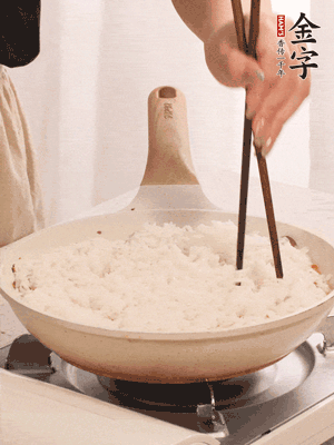 把瀝干水分的米飯均勻鋪在上面，筷子戳幾個洞，以便透氣，轉(zhuǎn)小火蓋上蓋子燜至水分收干，大概10分鐘。